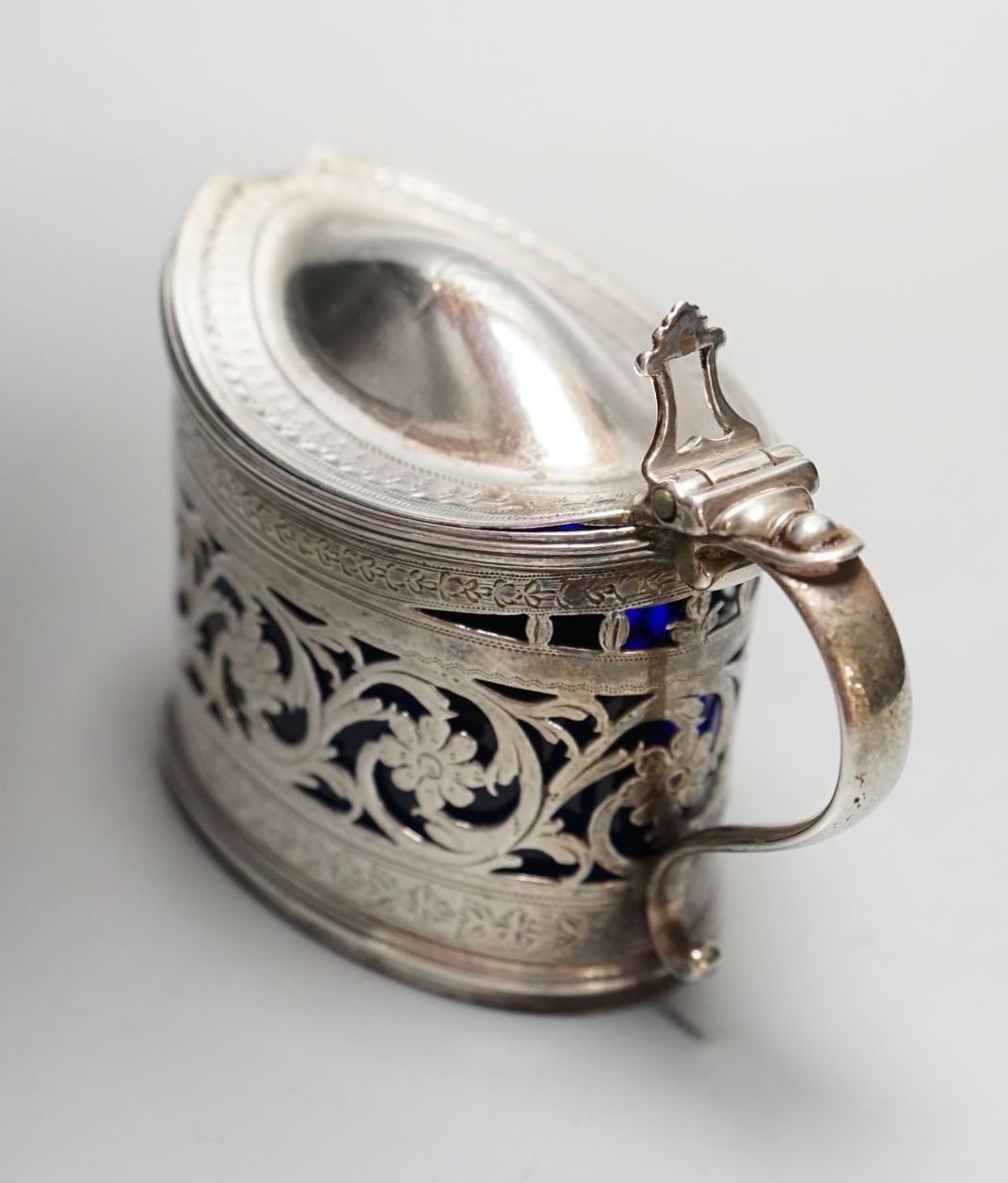 A George III engraved and pierced silver oval mustard pot, Michael Plummer, London, 1793, length 10cm.